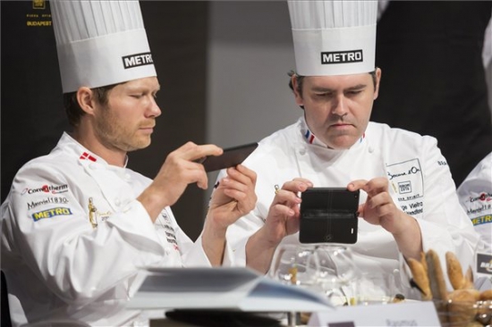 A dán Rasmus Kofoed (b) és a francia Serge Vieira, a zsűri elnökségének tagjai fényképeznek egy ételt a Bocuse d'Or szakácsverseny európai döntőjén. MTI Fotó: Mohai Balázs